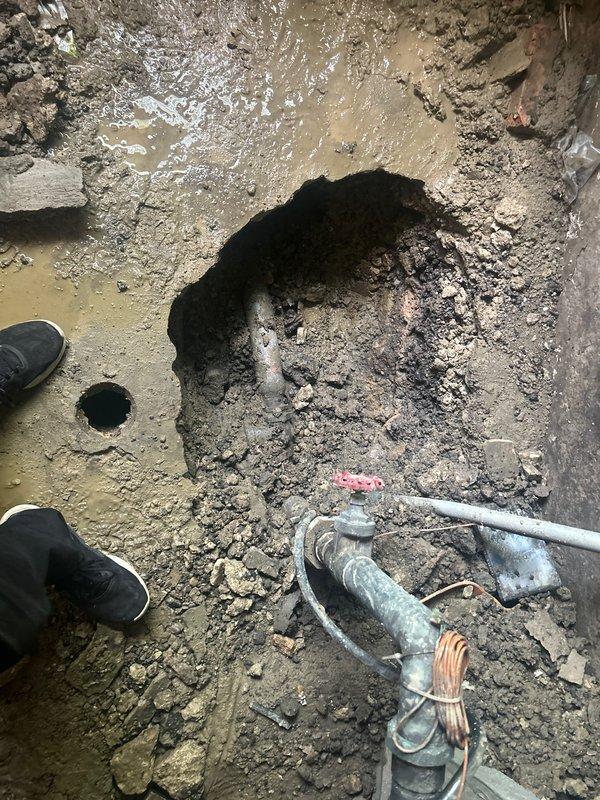 Responded to emergency service call for complete building water outage due to broken main water line. Upon arrival, conducted site assessment and documented conditions through photographic evidence. Excavation revealed compromised main water line beneath concrete floor with significant structural damage to surrounding foundation and flooring materials. Observed extensive water intrusion in basement area with standing water, sediment accumulation, and moisture damage to brick and concrete walls. Existing plumbing infrastructure showed deterioration from prolonged water exposure. Prepared comprehensive estimate for main water line replacement, including excavation of damaged concrete flooring, removal and replacement of failed water service line, restoration of foundation integrity, and remediation of water-damaged basement area with proper drainage considerations.