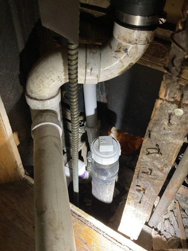 Responded to water leak originating from bathroom and extending to basement area. Located leak source in crawlspace beneath bathroom flooring, identifying compromised plumbing connections and PVC pipe assembly. Protected bathroom exhaust fan with plastic sheeting and secured with painter's tape to prevent water damage during leak assessment and repair preparation.