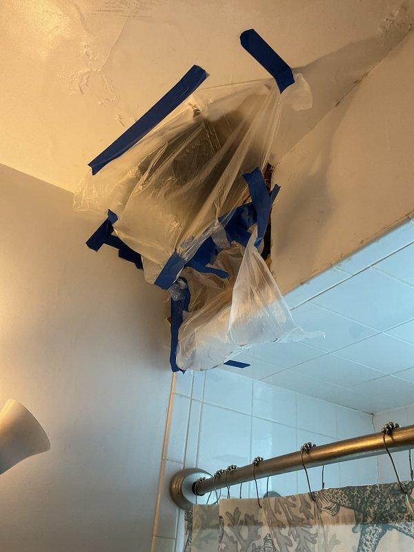 Responded to water leak originating from bathroom and extending to basement area. Located leak source in crawlspace beneath bathroom flooring, identifying compromised plumbing connections and PVC pipe assembly. Protected bathroom exhaust fan with plastic sheeting and secured with painter's tape to prevent water damage during leak assessment and repair preparation.