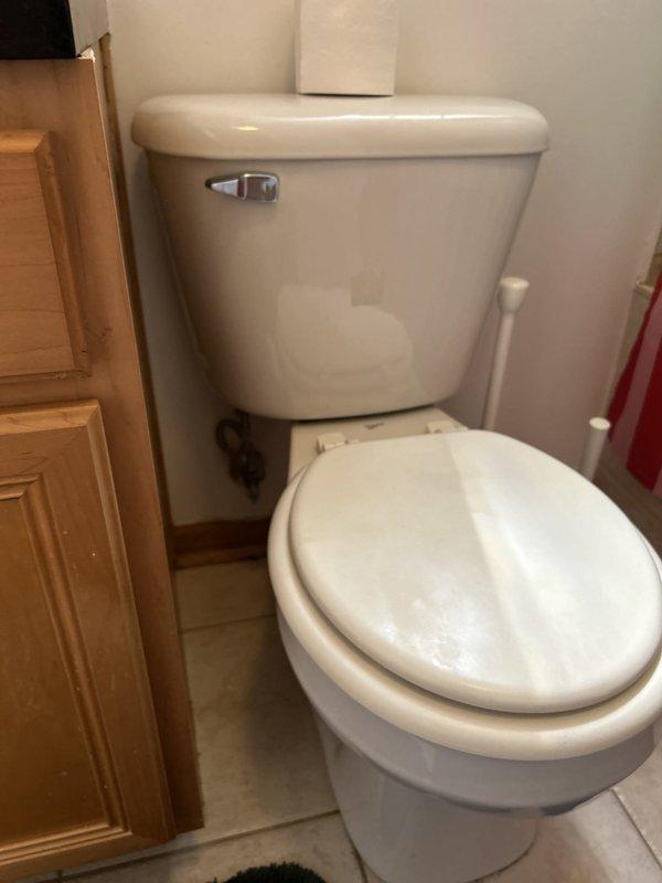 Responded to service call for whistling noise in bathroom shower and provided estimate for replacement of two residential toilets. Inspected existing toilet installations in bathroom, documenting current conditions of standard two-piece white porcelain toilets with chrome flush handles and proper water supply connections. Both units evaluated for replacement consideration. Photos captured showing existing fixtures, including tank and bowl configurations, mounting hardware, and surrounding bathroom conditions with beige tile flooring and standard residential plumbing connections.
