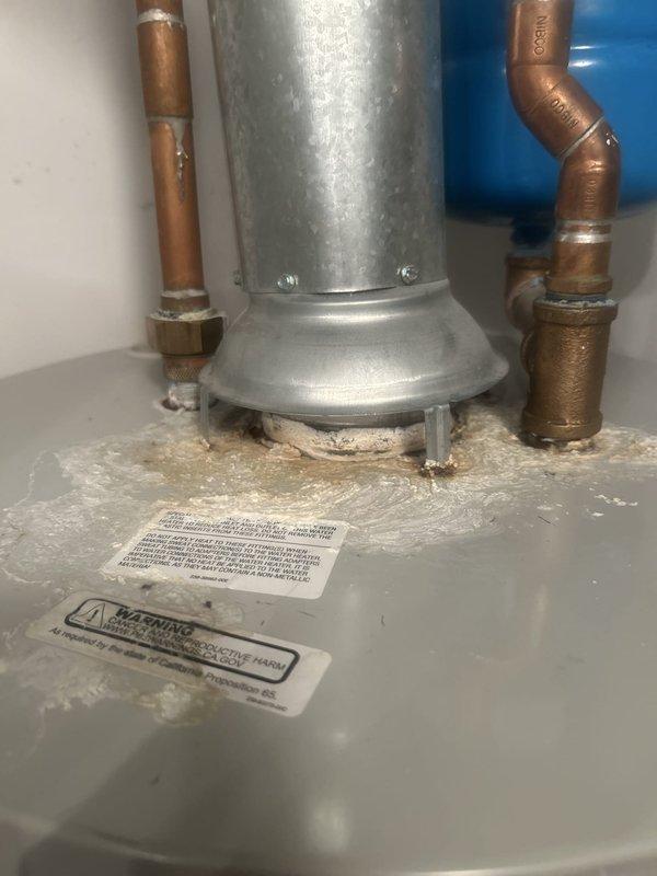 Performed routine maintenance flush on residential tanked water heater to remove sediment buildup and ensure optimal performance. Drained tank completely through bottom drain valve, flushed system with fresh water until discharge ran clear, and verified all copper supply lines, brass fittings, and connections for leaks. Inspected WATTS expansion tank, confirmed proper pressure relief valve operation, and documented equipment condition with pre- and post-service photographs showing installation in utility closet alongside HVAC system.