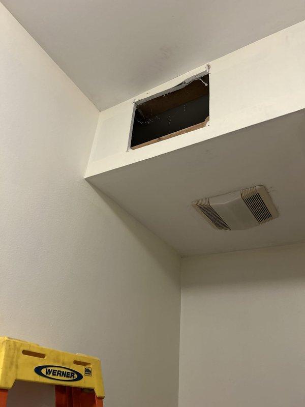 Completed plumbing repair work involving toilet flange inspection and bathroom ventilation system assessment. Accessed wall cavity through existing opening to evaluate exhaust fan installation and verified proper mounting of bathroom ventilation unit. Inspected toilet flange assembly, noting accumulated debris and wear around the seal area, and assessed corroded water supply valve requiring attention for future maintenance considerations.