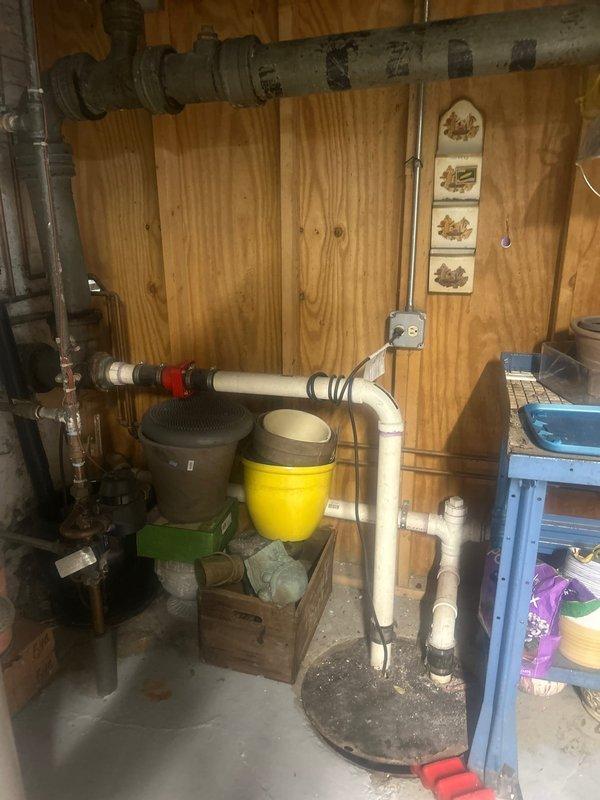 Responded to callback for drum trap removal and waste overflow replacement. Removed obsolete drum trap assembly from basement plumbing system and installed new PVC P-trap configuration with proper waste and overflow connections. New installation features white PVC piping with appropriate fittings and red coupling valve for system control. Work completed in utility room area with all connections properly sealed and tested for leaks.
