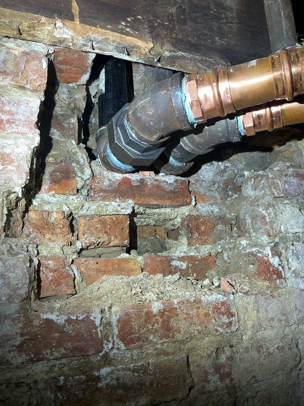 Responded to emergency water main repair in older residential property. Upon inspection, identified deteriorated copper water supply lines in basement area with compromised joints and fittings near aged brick foundation wall. Replaced damaged sections of water pipe including corroded compression fittings, restored proper water flow to affected areas of the home, and verified system integrity with pressure testing to ensure no additional leaks were present.