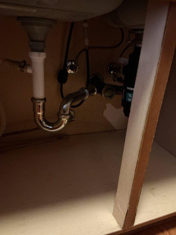 Responded to a service call for a kitchen sink draining slowly. Upon inspection, accessed the cabinet area beneath the sink and examined the plumbing configuration, which included a garbage disposal unit, P-trap assembly, and associated drainage pipes. Assessed the disposal unit and drain connections for blockages or improper drainage flow. Cleared the obstruction causing the slow drain condition, restoring proper water flow through the sink and disposal system.