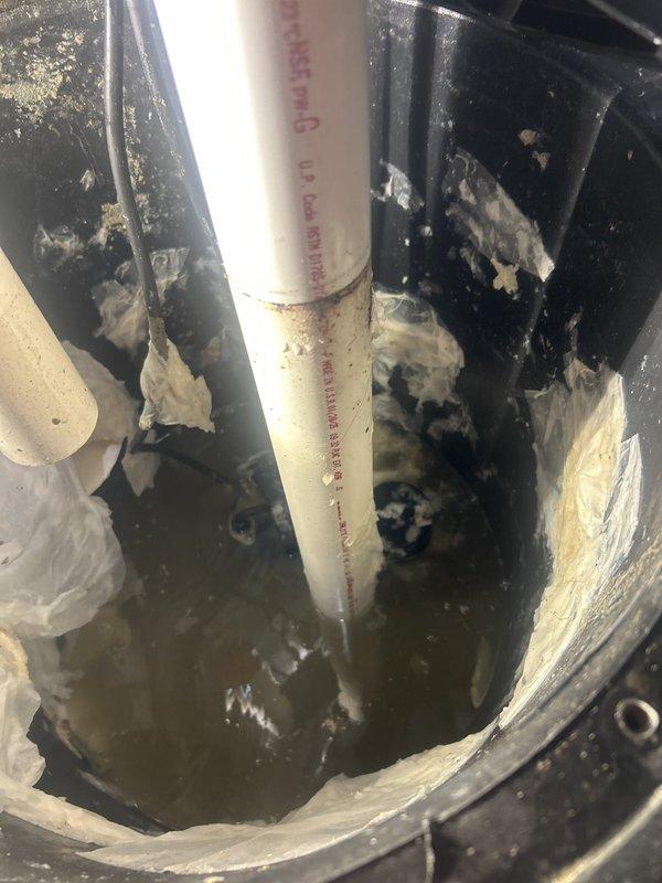 Responded to service call for ejector pump running continuously with water backing up into the pit. Upon inspection, found ejector pump system with visible moisture accumulation and deterioration of surrounding insulation materials. Assessed PVC discharge piping, check valve assembly, and pit conditions to diagnose flow restriction issue causing constant pump cycling and inadequate drainage.