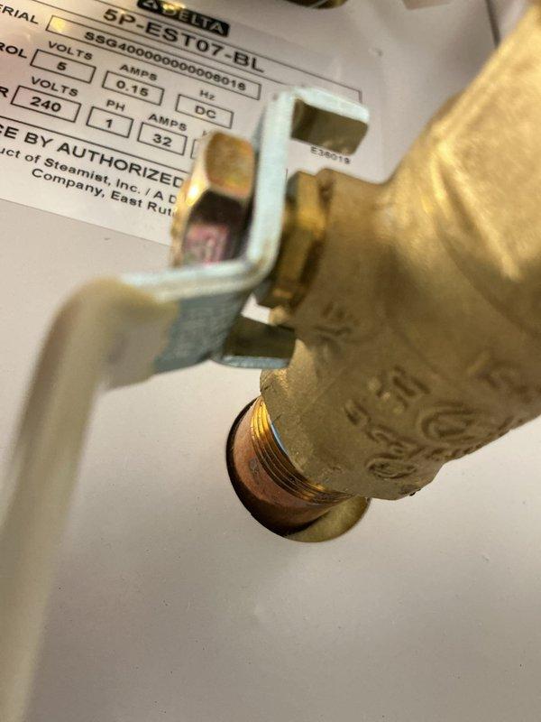 Inspected steam generator system connected to shower/tub installation. Documented brass valve fitting and connections on Steamist unit, noting weathered condition of brass components with visible patina. System requires further assessment and consultation to determine next steps for completion or repair.