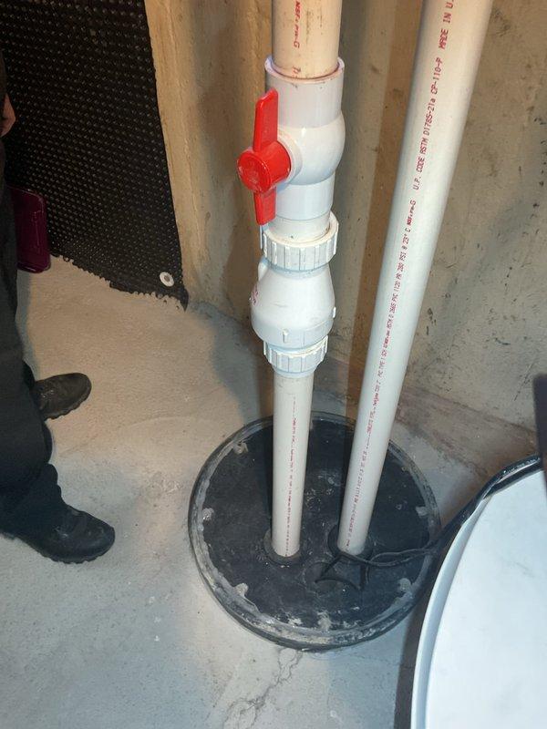 Completed annual maintenance on sump pump system in 70-year-old residential property. Inspected sump basin, verified pump operation and float switch functionality, and tested discharge piping with red ball valve isolation system. Confirmed proper drainage through PVC discharge lines, checked basin water levels, and verified electrical connections. All components operating within normal parameters with no issues identified during inspection.