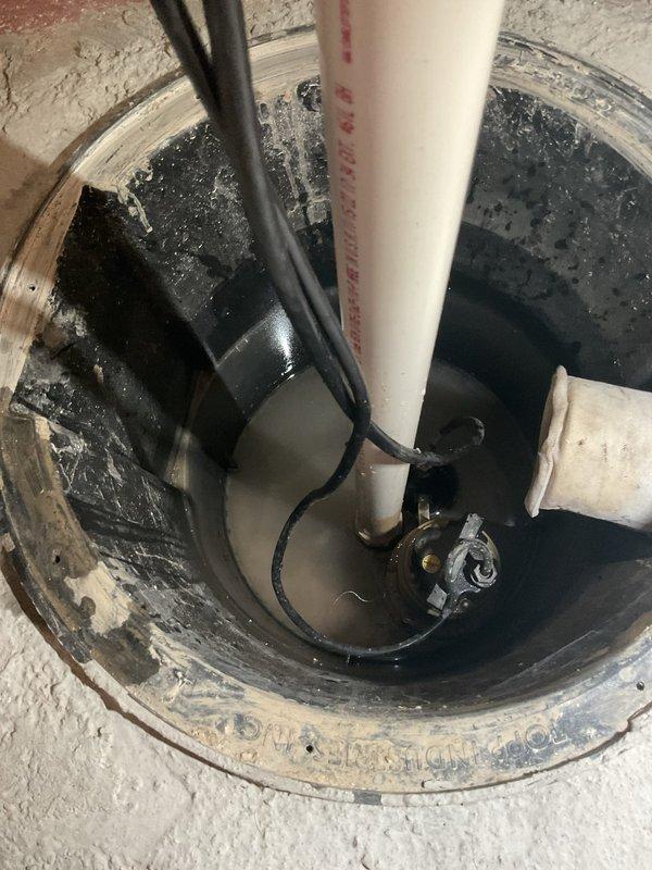 Completed annual maintenance on sump pump system in 70-year-old residential property. Inspected sump basin, verified pump operation and float switch functionality, and tested discharge piping with red ball valve isolation system. Confirmed proper drainage through PVC discharge lines, checked basin water levels, and verified electrical connections. All components operating within normal parameters with no issues identified during inspection.