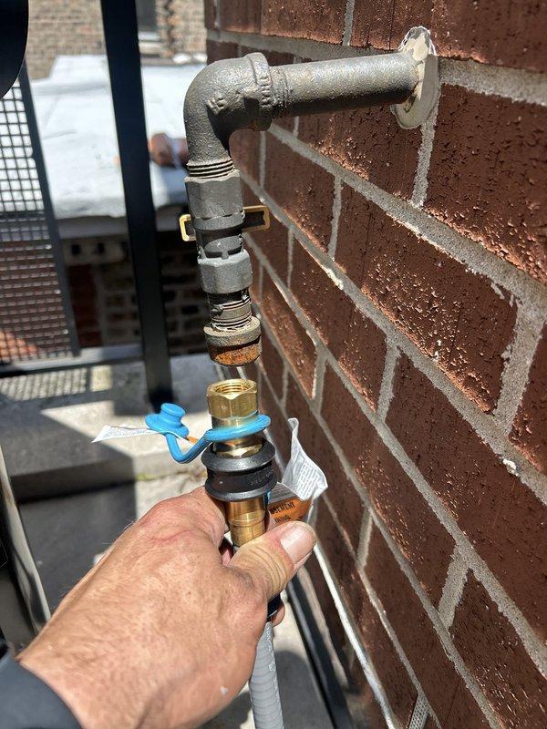 Completed faucet installation at exterior hose bib location and kitchen sink. Installed new brass hose connector and valve assembly at outdoor spigot mounted to brick exterior wall, ensuring proper weatherproofing and secure connections. Under kitchen sink, installed new faucet with chrome supply lines, braided stainless steel flexible hoses, shut-off valves, and integrated the cylindrical mounting assembly with existing PVC drain system and P-trap configuration.