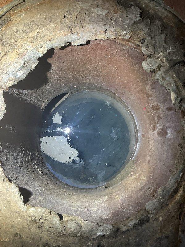Responded to service call for malfunctioning sump pump producing excessive noise. Upon inspection, found heavily corroded and deteriorated sump pump system in basement utility area with significant age-related wear. Sump basin contained dark, sediment-filled water with visible debris accumulation. Concrete floor surrounding pump exhibited extensive water staining and damage patterns indicating chronic moisture issues and possible past flooding events. Primary pump unit showed advanced rust and corrosion on exterior housing with multiple pipe connections in compromised condition. Basement walls displayed peeling paint and moisture damage consistent with long-term water management problems. Documented existing conditions through photographic evidence for estimate preparation. Assessed complete sump pump replacement necessary due to equipment failure and deterioration beyond serviceable repair. Provided comprehensive evaluation of system requirements for proper water removal and basement 