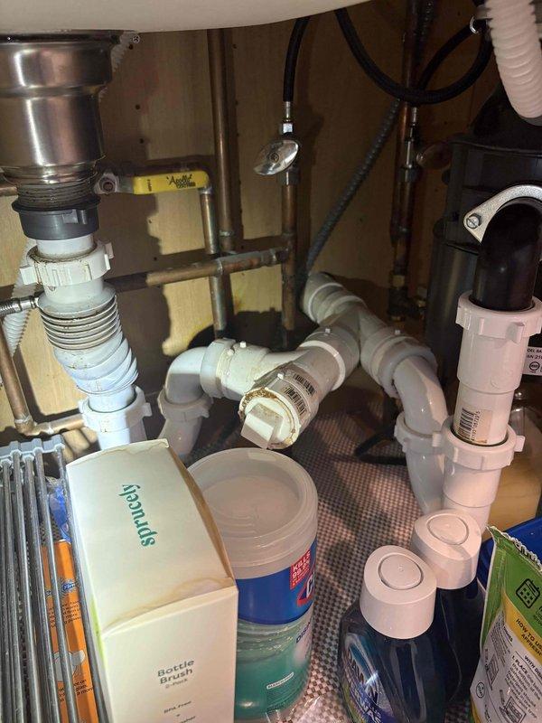 # Plumbing Inspection and Deficiency Assessment

Conducted a comprehensive plumbing system inspection identifying multiple code compliance issues and safety concerns requiring corrective action.

## Crawlspace Drainage System

Inspected condensate drainage connections in the crawlspace and identified a saddle drain tap installation. This connection method does not meet approved plumbing standards and presents significant risk for leakage or system failure. Documented the condition with photographs for repair planning.

Evaluated drain line support systems throughout the crawlspace. Found inadequate support using improvised materials including a five-gallon bucket and PVC sections serving as hangers. These non-compliant supports fail to meet building code requirements and may cause improper drainage slope, stress on pipe connections, and potential system failure. Proper approved hangers are required for code compliance.

## Water Heater System Evaluation

Examined the water heater insta