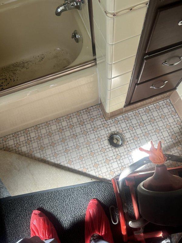 Responded to a clogged bathroom sink that was causing backup into the bathtub in an 80-year-old home. Upon arrival, found significant dark sediment and debris accumulated in the bathtub basin, indicating a substantial drainage blockage in the shared waste line. The homeowner had attempted unsuccessful DIY clearing methods over the previous two days before service call.

Assessed the plumbing configuration and determined the clog was located in the common drain line serving both fixtures. Utilized professional drain clearing equipment to access and clear the obstruction from the drainage system. Removed accumulated sediment, debris, and buildup that had caused the backup condition. 

Successfully restored proper drainage function to both the bathroom sink and bathtub. Verified water flow through both fixtures and confirmed no residual blockage remained in the waste lines. Left work area clean and advised homeowner on proper drain maintenance practices to prevent future occurrences in th