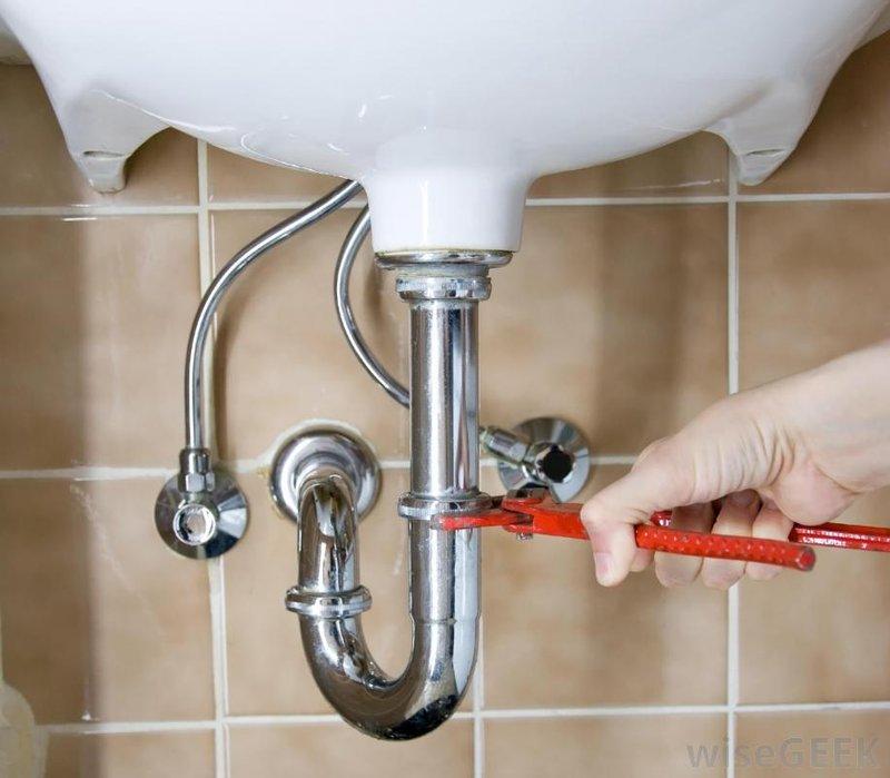 Completed under-sink plumbing repair involving P-trap assembly replacement and drain line service beneath dual bathroom sink. Utilized professional plumbing tools to remove and reinstall chrome-finished P-trap configuration, addressing drainage issues and ensuring proper trap seal for both sink basins.