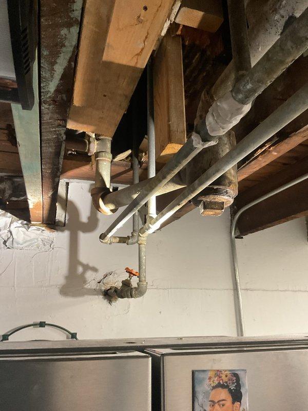 Completed plumbing repairs in bathroom including addressing a toilet leak suspected to originate from a faulty O-ring seal. Inspected and serviced mechanical room equipment, including stainless steel water heater/boiler system with associated copper piping manifold, circulation pump, and valve assembly. Documented all work with photographs showing existing plumbing infrastructure and installed equipment.