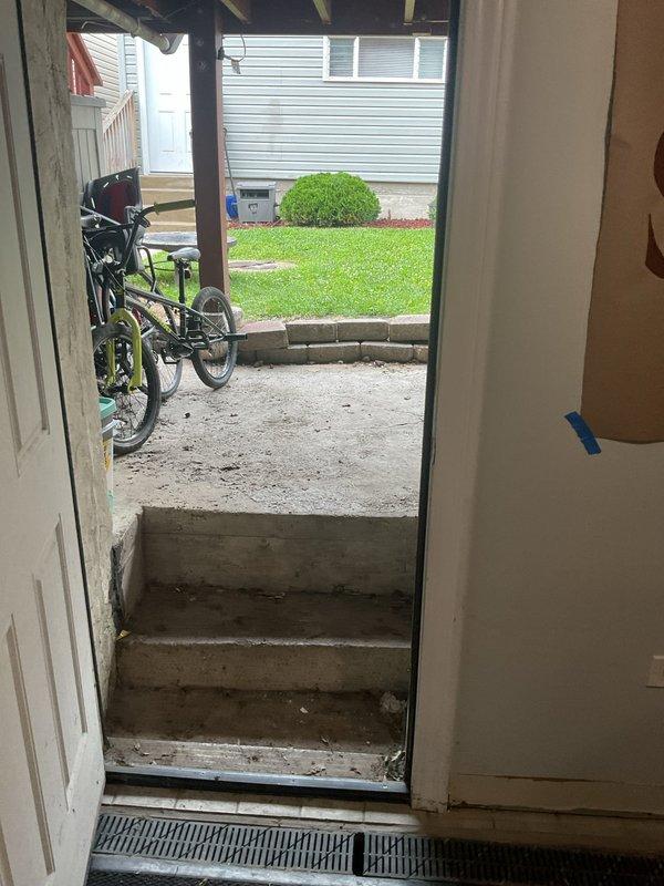 Responded to basement flooding complaint at residential property. Upon arrival, water had receded but customer requested assessment of water damage and identification of source. Located and inspected main drain cleanout access point in front yard, which showed signs of age and weathering consistent with the older home. Cleanout cover displayed significant rust and corrosion on metal components. Assessed interior threshold area and basement entry points for water intrusion evidence. Documented conditions of exterior cleanout access and interior doorway areas with photographs for record. Recommended drain rodding service to clear potential blockages in main sewer line that may have contributed to backup and flooding event.