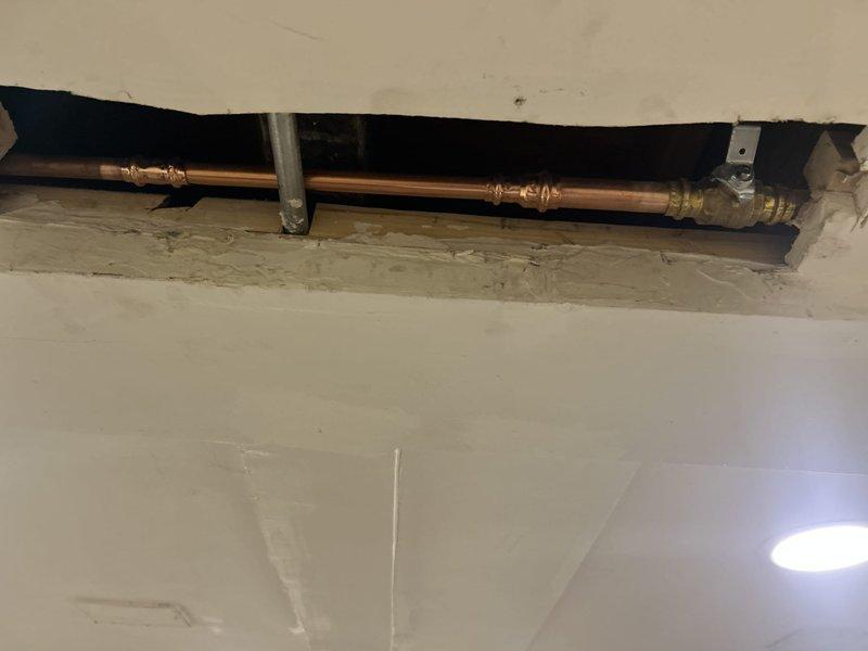 Responded to reported leak from outdoor spigot with low water pressure. Accessed supply line through interior wall opening, located leak at compression fitting on copper pipe run. Repaired connection and secured piping with proper mounting brackets. Also diagnosed and addressed noise issue with third-floor toilet fill valve during tank refill cycle.