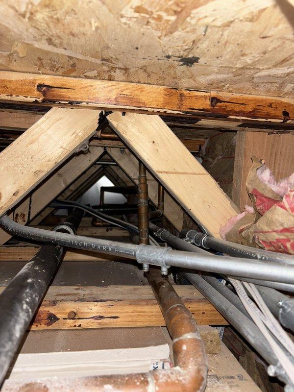 Completed tankless water heater installation in attic space, routing new copper supply lines and PVC venting through existing structural framework. Secured all piping connections with proper fittings and joints, ensuring compliance with code requirements for gas-fired tankless units in confined spaces with adequate combustion air and ventilation access.