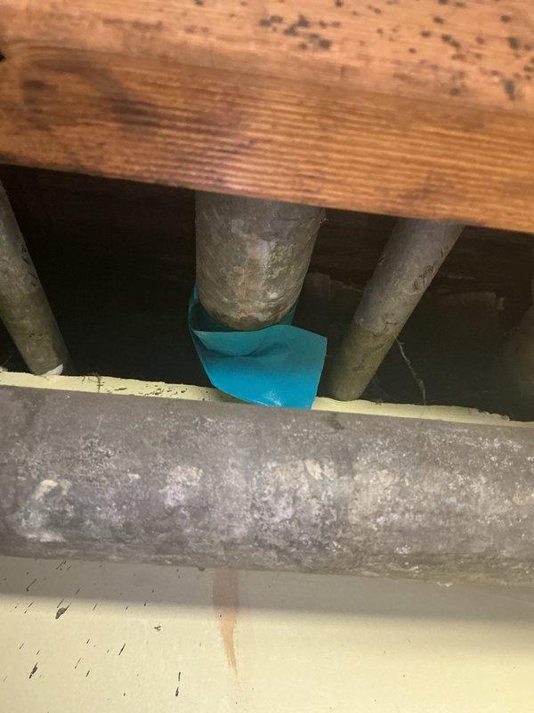 Technician responded to address a clogged kitchen sink and performed rodding service to clear the drainage system. Following the rodding procedure, a leak was discovered in the plumbing system beneath the sink area. Upon inspection of the crawl space, aging metal piping with visible corrosion and mineral deposits was identified as the likely source of the leak, potentially compromised during the rodding process. Documentation photos were taken of the affected plumbing infrastructure, including the corroded horizontal drain line and surrounding pipe connections. Customer was advised that a qualified plumbing estimate is required to assess the extent of pipe damage and determine necessary repairs or replacement of the deteriorated piping system.