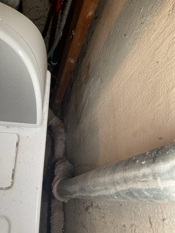 # Washing Machine Drain Backup - Basement

Responded to recurring drainage issue affecting basement washing machine drain line in 75-year-old residence. Customer reported backup had returned approximately two weeks prior, despite previous service 1-2 months ago. Upon arrival, accessed drain line through confined wall cavity space behind washing machine location.

Inspection revealed deteriorated drainage piping consistent with age of home's original plumbing infrastructure. Located blockage in main drain line serving washing machine discharge. Utilized mechanical auger to clear obstruction from drain system. Removed accumulated debris, soap residue, and sediment buildup that had reformed in aging cast iron or galvanized piping.

Given the recurrent nature of the blockage and advanced age of the plumbing system, advised customer that underlying pipe deterioration may be contributing to repeated backup issues. The original drainage piping shows signs of scale buildup and internal corrosi