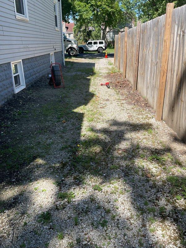 Performed video camera inspection of residential sewer line to evaluate system condition and identify the point of connection to the main. Accessed sewer line through available cleanout in narrow side yard area between house and fence, navigating equipment through confined workspace with gravel and dirt surface. Successfully completed camera inspection of the entire sewer lateral, documenting findings with video footage to provide accurate assessment for repair or replacement recommendations.