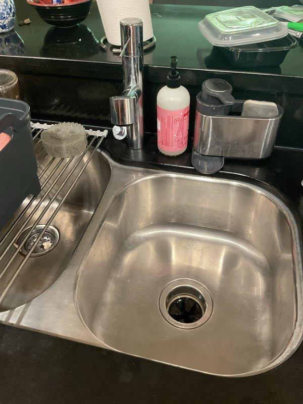Completed installation of new P-trap assembly and drain components under bathroom sink. Replaced existing drain piping with chrome-plated P-trap, compression fittings, and black plastic tailpiece extension to ensure proper drainage and prevent leaks. All connections were secured with compression nuts and tested for proper water flow and seal integrity.