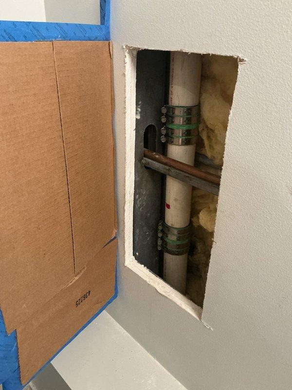 Performed drain and sewer camera inspection service requiring wall access to evaluate plumbing infrastructure. Created access opening in bathroom wall to expose vertical drainage pipes and horizontal supply lines for thorough visual assessment. Documentation completed with photographic evidence of pipe conditions, including PVC drainage system and copper supply lines within wall cavity.