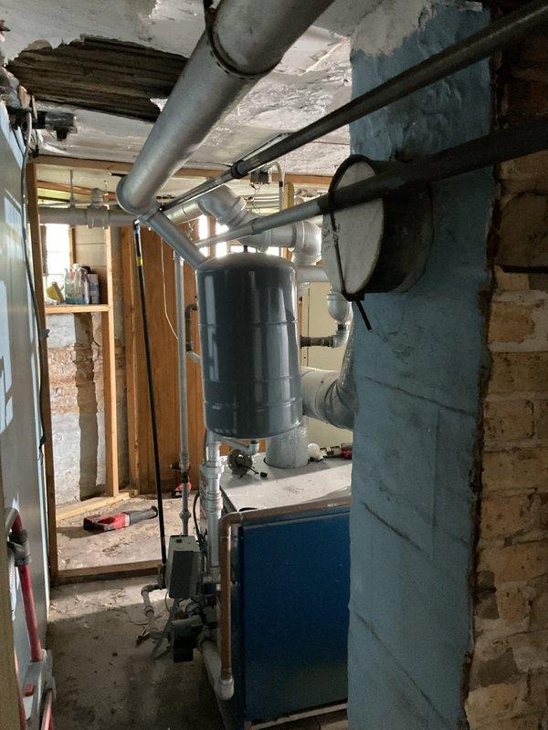 Responded to emergency plumbing call for consistent drip leak in basement mechanical room. Upon inspection, identified deteriorated pipe connection in older plumbing system that was heavily coated and inaccessible without demolition work. Unable to locate individual shutoff valve for affected line; determined whole-house water shutoff would be required for proper repair. Assessed basement area with exposed joists, HVAC ductwork, and water heater installation. Located main water shutoff at exterior meter pit. Leak currently contained but requires follow-up service for pipe replacement and potential rerouting of supply lines. Documented existing conditions including aged infrastructure and limited access points. Recommended scheduling comprehensive repair work to address deteriorated piping and install accessible isolation valves for future maintenance.