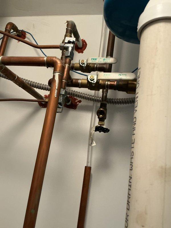 Inspected indoor plumbing connections and outdoor spigot system to diagnose service issue. Identified necessary replacement part for outdoor spigot/shower assembly. Documented existing copper piping configuration, valve assemblies with ball valves, and water heater connections in utility area. Measured and assessed outdoor installation location on deck surface using specialized crimping and fitting tools. Order placed for required component, with installation scheduled upon part arrival.