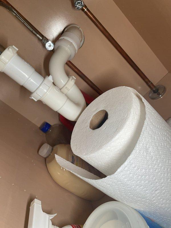Responded to service call for slow-draining bathroom sink that was filling up with water during use. Upon inspection, found white porcelain sink with visible pooling water and drainage issues. Examined sink basin, drain stopper assembly, and chrome fittings. Assessed under-sink plumbing configuration, including white PVC P-trap assembly, water supply lines with braided hoses, and wall-mounted shut-off valves. Documented existing condition showing aged sink with chipped finish along back edge near faucet area. Evaluated drainage system components to identify source of blockage causing water backup and slow drainage in bathroom sink.