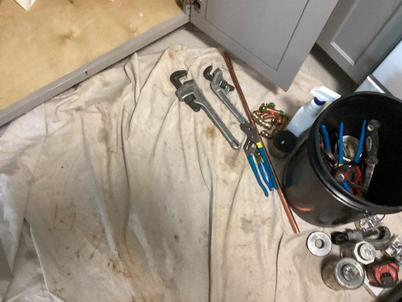 Completed dual-sink angle stop replacement under kitchen cabinet following coordinated building shutdown. Removed existing twin angle stops from 1/2" threaded nipples and installed new copper supply piping configuration with four angle stops—two for hot water supply and two for cold water supply. After installation, building management restored water pressure to lines, and all connections were thoroughly inspected and verified leak-free before returning system to service.