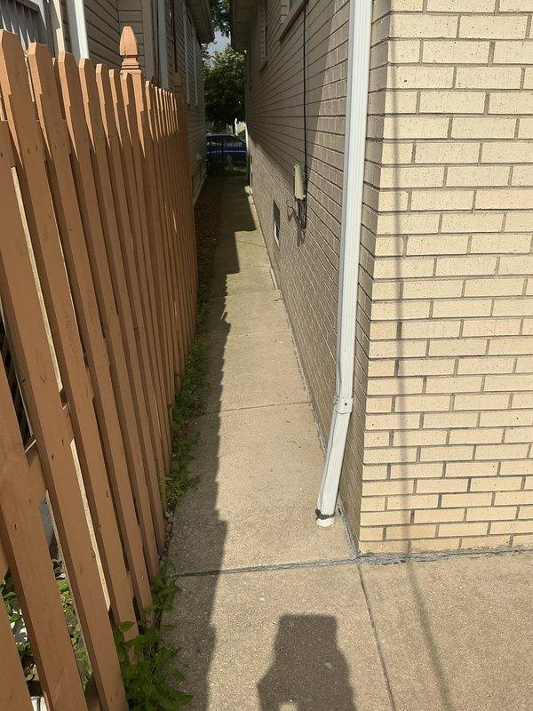 Performed camera inspection of downspout drainage line to investigate suspected blockage in underground system. Accessed downspout connection point along side yard walkway and deployed sewer camera equipment through the line to assess interior condition and identify any obstructions or clogs affecting proper water drainage.