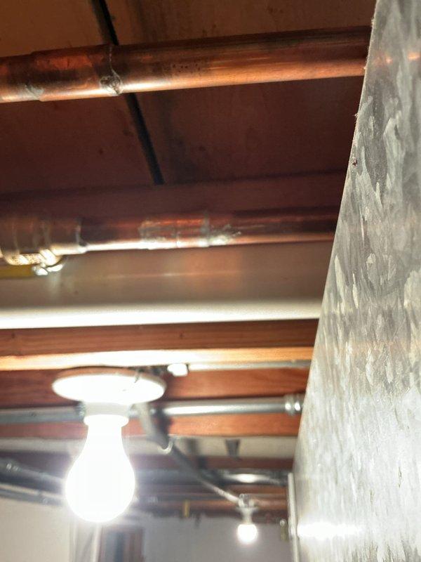 Responded to water leak on main supply line feeding water heater in basement. Upon inspection, identified active leak at connection point between main line and water heater supply piping. Repaired compromised connection on aging copper and steel pipe system, verified all joints for integrity, and tested system under full pressure to confirm leak resolution and proper water flow to water heater.