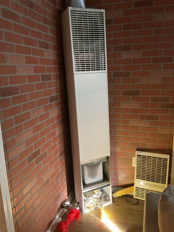 Responded to emergency gas odor call at residential property. Upon arrival, located gas smell near wall-mounted heating unit in corner room with exposed brick walls. Inspected heating equipment with open access panel and assessed gas valve operation. Conducted safety evaluation of gas piping system, tested for leaks, and verified proper gas pressure levels to ensure safe operation of heating appliances.