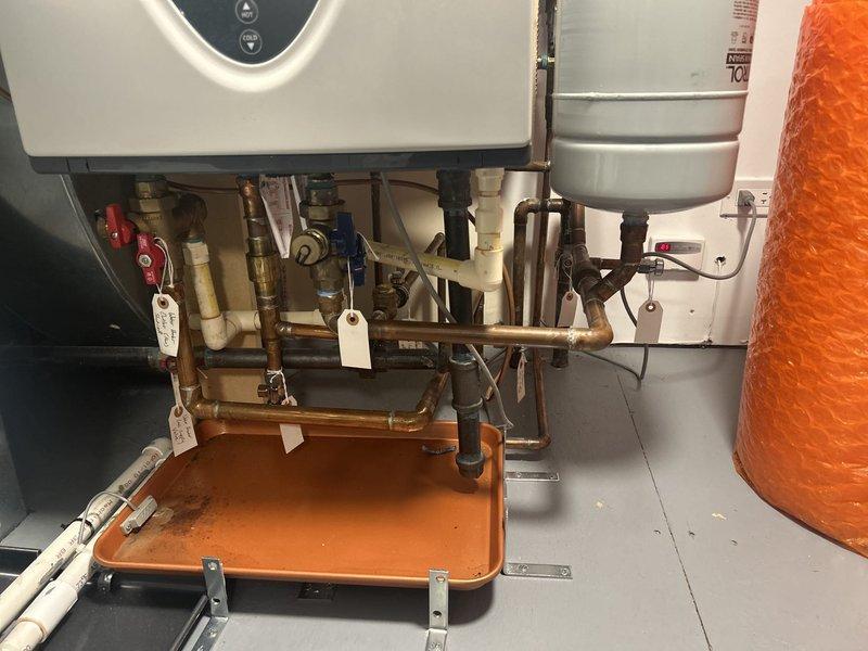 Performed comprehensive maintenance service on AO Smith tankless water heater unit. Inspected digital control panel displaying operational temperature of 140°F and verified all control functions operating properly. Examined complete plumbing assembly including copper supply lines, PVC venting system, expansion tank, and associated shut-off valves for proper operation and potential leaks. Verified drain pan placement and condition beneath equipment for adequate leak protection. Confirmed all system components, connections, and safety devices functioning within manufacturer specifications.