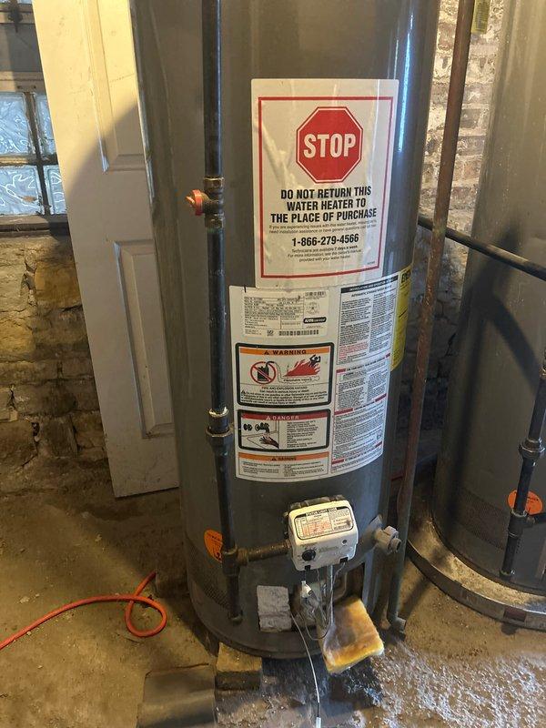 Responded to no hot water condition at residential property. Upon arrival, found existing water heater with evidence of significant water damage and flooding on concrete floor around unit base. Connected new tanked water heater installation in basement utility area, completing all necessary plumbing connections including hot and cold water supply lines and pressure relief valve piping. Installed shut-off valves at top connections and verified proper drainage configuration. Tested all connections for leaks, confirmed adequate water pressure, and verified unit operation to restore hot water service to the residence.