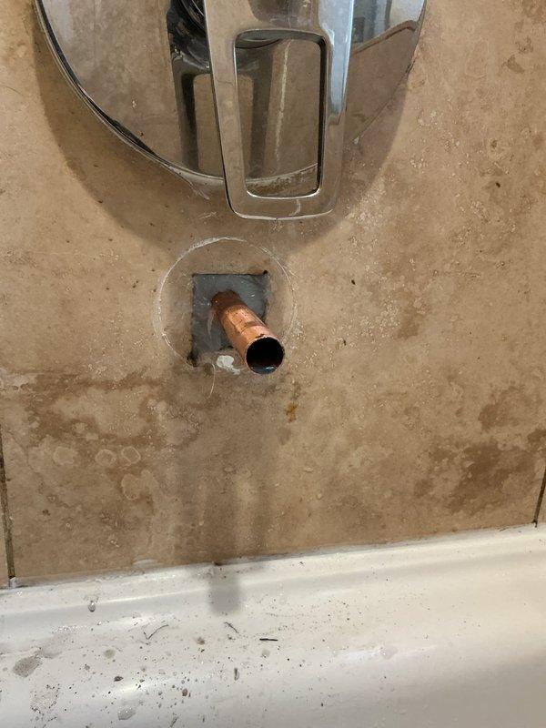 Responded to ongoing leak complaint and performed diagnostic inspection of bathtub plumbing system. Accessed wall cavity through existing opening to examine copper supply piping and shower valve assembly. Inspected chrome-finished single-handle mixing valve, tub spout, and associated connections for signs of water intrusion. Documented conditions with photos showing rough-in plumbing, valve trim installation, and surrounding tile work. Leak source not definitively identified during this visit; further investigation required to isolate and resolve the issue.