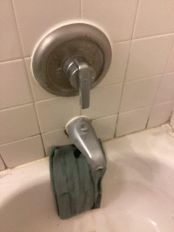 Completed comprehensive plumbing inspection of all valves and drains throughout the property to assess repair needs and provide accurate estimates. Examined bathroom bathtub fixtures, including brushed nickel faucet assembly with single lever handle and chrome tub spout with diverter button, noting visible deterioration around spout base connection with gaps in caulking seal and signs of water exposure. Documented aging grout lines with discoloration, brownish staining, and accumulated buildup around tile work, indicating potential moisture intrusion issues requiring attention.
