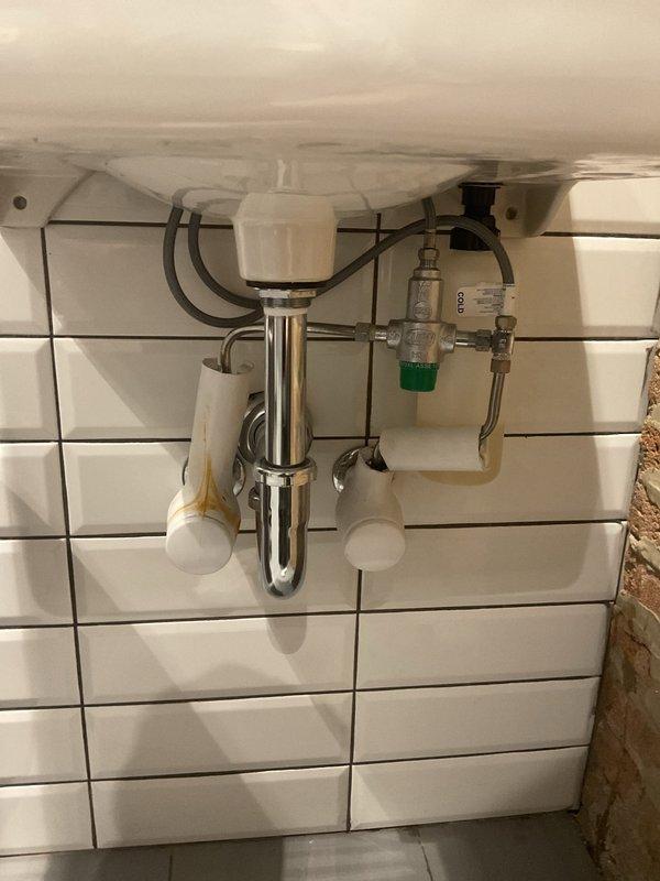 Responded to service call for grease trap cleaning and drain odor investigation at commercial kitchen facility. Upon arrival, inspected kitchen drain system and identified source of foul odors related to drain line buildup. Performed thorough cleaning of grease traps to remove accumulated fats, oils, and grease causing drainage issues and malodors. Disassembled and inspected P-trap assemblies under sinks, cleared blockages, and verified proper drainage flow. Reassembled all plumbing components including chrome traps, shut-off valves, and supply lines. Tested all fixtures for proper operation and confirmed elimination of odor issues and restoration of normal drainage function.