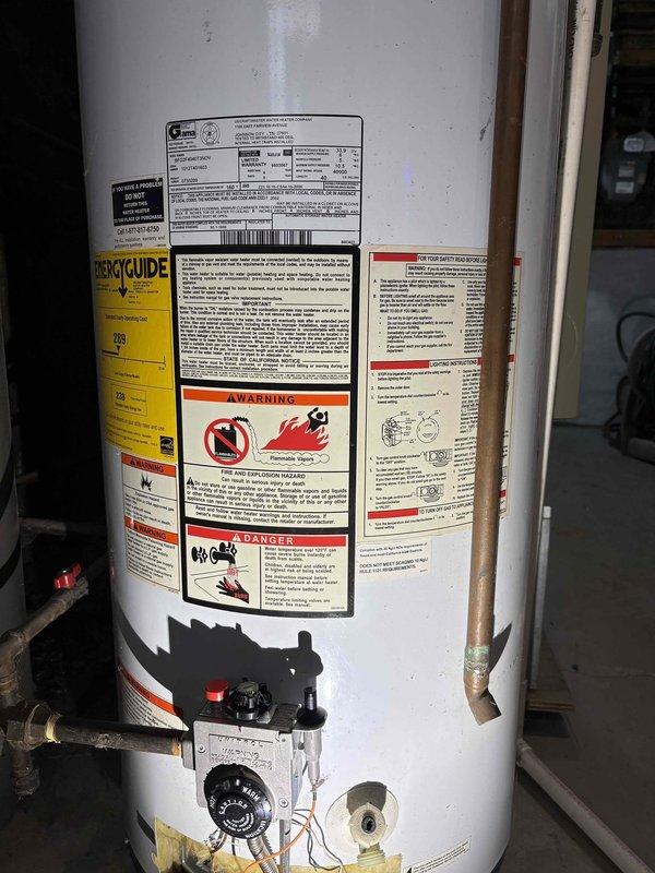 Performed comprehensive inspection and documentation of existing gas-fired tanked water heater installation in residential utility space. Unit evaluated for proper operation, safety compliance, and overall condition. Verified copper supply and discharge piping connections, gas valve assembly, temperature and pressure relief valve, and thermostat control functionality. Documented current state of installation including warning labels, energy guide information, and all safety placards for service records. Noted age-related discoloration at tank base and minor surface wear consistent with normal operational use.