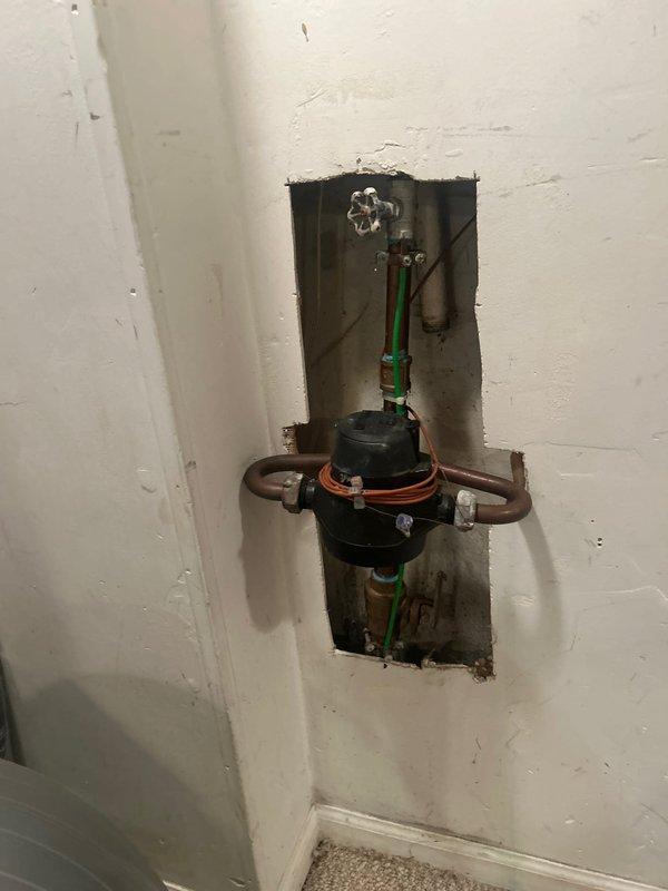 Completed installation of wall-mounted bathroom sink with chrome faucet fixture and exposed P-trap plumbing assembly. Additionally installed plumbing components within wall cavity including backflow preventer with copper pipe connections and pressure regulation system. Customer awaiting additional parts for project completion.
