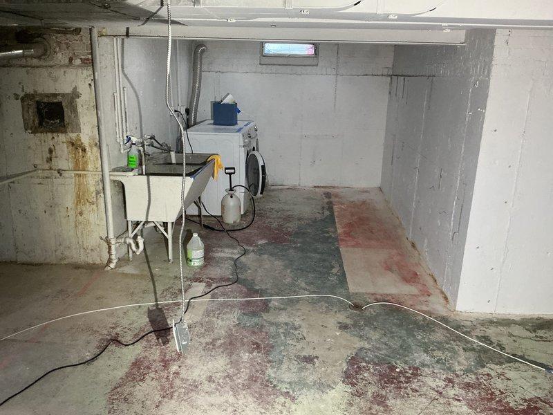 Conducted site assessment and provided estimate for installation of new interior tile drain system in unfinished basement with no existing drainage infrastructure. Evaluated concrete floor conditions, existing plumbing configuration, and structural considerations in 1957 construction home. Documented basement layout including exposed floor joists, concrete walls with visible form tie patterns, and current utility placement to determine optimal drain routing and installation approach for proposed tile drain system.