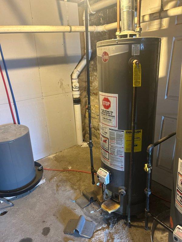 Replaced failed tanked water heater in basement utility room due to water leakage at base of unit. Removed existing water heater, installed new Rheem Performance series tanked water heater with proper venting through existing metallic flue pipe, connected supply and discharge plumbing lines, and verified all connections for proper operation and no leaks.