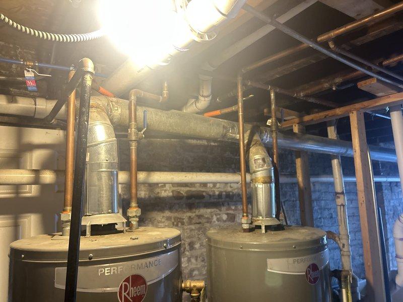 Replaced failed tanked water heater in basement utility room due to water leakage at base of unit. Removed existing water heater, installed new Rheem Performance series tanked water heater with proper venting through existing metallic flue pipe, connected supply and discharge plumbing lines, and verified all connections for proper operation and no leaks.