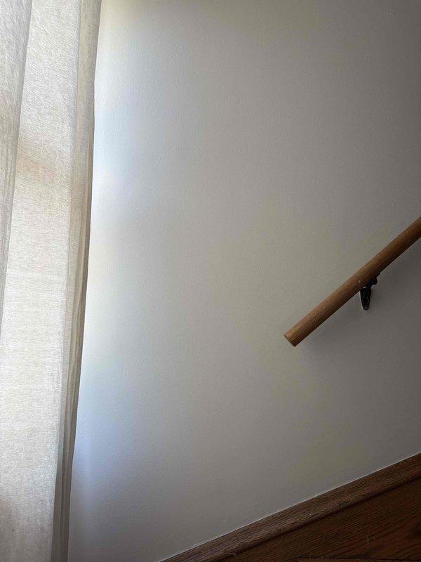 Responded to a plumbing-related wall access opening near a stairwell handrail area. Created a large rectangular access point through drywall to expose internal plumbing infrastructure, revealing vertical wooden studs and wall cavity for inspection or repair of concealed water lines. The controlled demolition allowed proper assessment and access to address the plumbing issue identified during the initial consultation.