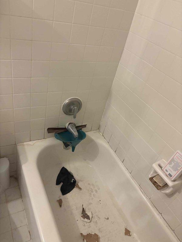 Completed plumbing estimate for piping assessment in residential bathroom. Evaluated existing bathtub, shower fixtures, and associated plumbing connections to determine scope of work for potential re-piping or fixture replacement. Documented current condition of chrome faucet assembly, spout fixture, and shower control valve for estimate preparation.