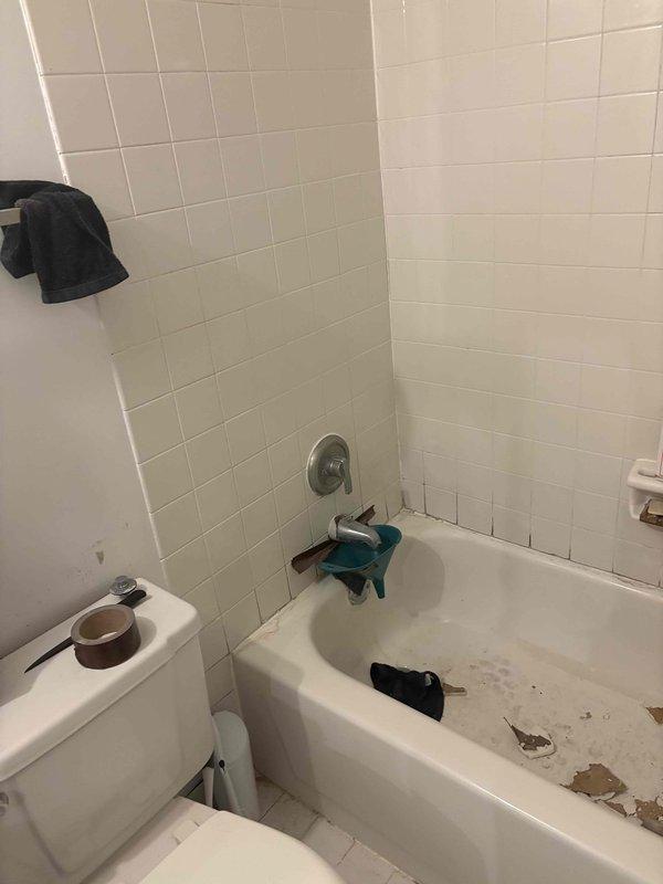 Completed plumbing estimate for piping assessment in residential bathroom. Evaluated existing bathtub, shower fixtures, and associated plumbing connections to determine scope of work for potential re-piping or fixture replacement. Documented current condition of chrome faucet assembly, spout fixture, and shower control valve for estimate preparation.