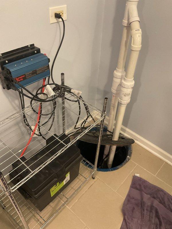 Scheduled follow-up diagnostic appointment for next week to evaluate Champion backup sump pump system installed in 2025, currently under warranty. Documented existing system configuration including battery backup unit, PVC discharge piping, and dual float switch assembly in utility room sump basin.