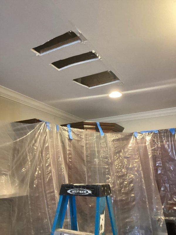 Installed water filtration system and shower head fixture in tiled bathroom enclosure with chrome finish components. Created ceiling access points and established dust containment protocols using protective plastic barriers to facilitate plumbing system modifications and ensure work area remained clean during installation process.