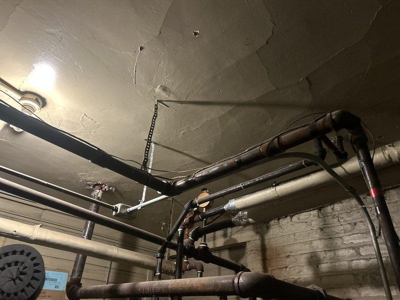 Completed plumbing estimate for kitchen remodel in century-old home requiring pipe relocation, sink repositioning, and gas line capping. Assessed existing plumbing infrastructure in basement mechanical space, documenting overhead piping network including black insulated lines, metallic supply pipes, PVC drainage system, and gas distribution lines. Evaluated structural conditions and developed scope of work to accommodate kitchen layout modifications while maintaining code compliance in aged residential structure.